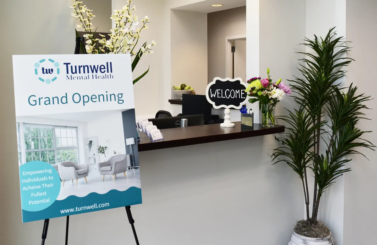 Grand opening of Turnwell Mental Health in Atlanta, Georgia, highlighting the facility’s advanced mental health treatments. The image showcases a modern, welcoming space dedicated to innovative therapies, including TMS therapy, IV ketamine infusions, and both group and individual psychotherapy. A large promotional banner features Turnwell’s commitment to personalized care, empowering individuals on their mental health journey.