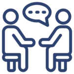 Group psychotherapy icon featuring two simplified human figures sitting on chairs facing each other with a speech bubble containing three dots between them, symbolizing communication and therapeutic conversation in a group setting.