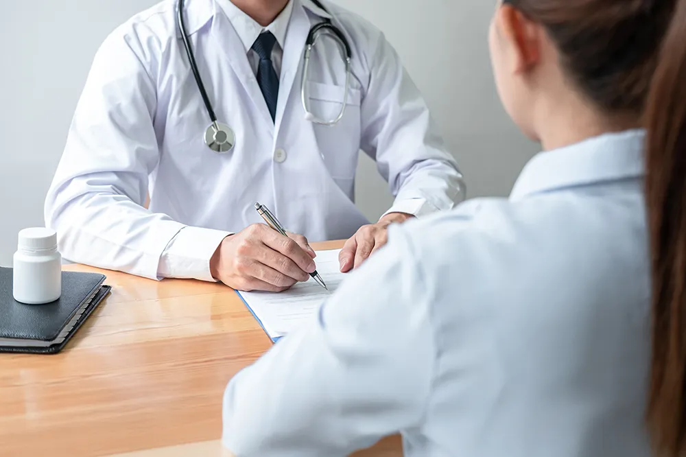 A doctor is assisting a patient with medication management, ensuring they understand their prescriptions and how to take them properly. The doctor is holding a clipboard and discussing the medication plan with the patient, who looks attentive and engaged.