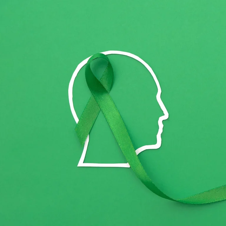 Green mental health awareness ribbon with the outline of a head, promoting a complete guide for National Depression and Mental Health Screening Month.